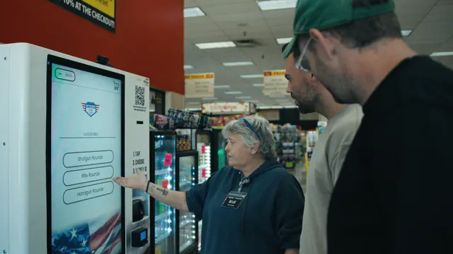 Blue shows Josh and Tommy the ammunition vending machine at Fresh Value in Pell City, Alabama.