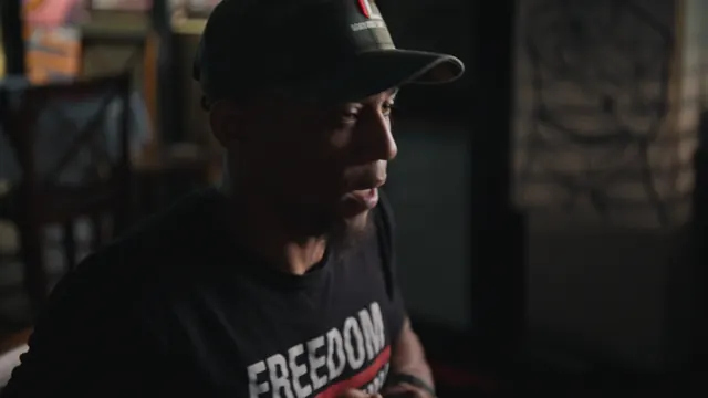 Devin Perkins, who introduced the filmmakers to Kids to Kings, in a cap and a FREEDOM T-shirt.