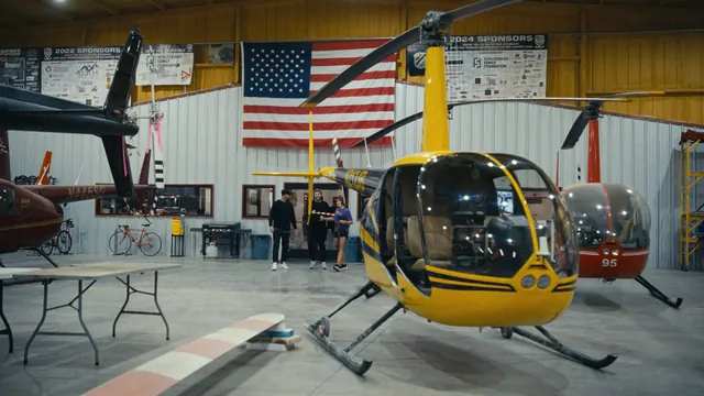 A helicopter beneath an American flag in a Texas hangar, before the feral hog hunt.
