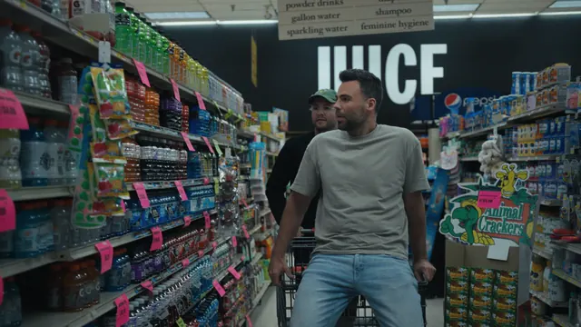 Tommy rides in a shopping trolley as Josh pushes him down a supermarket aisle in Alabama.