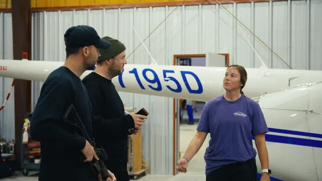 Georgia Tucker of Cedar Ridge Aviation gives Tommy, rifle in hand, and Josh a safety briefing in the hangar before the feral hog hunt in Texas.