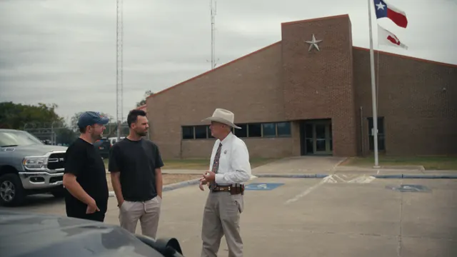 Sheriff Roy Boyd of Goliad County talks with Tommy and Josh outside his office.