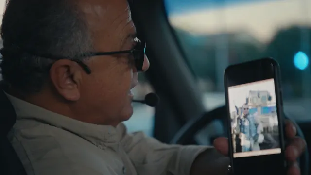 Sammy Dorian, a Hollywood tour-bus guide, shows a photo from his time as a civilian contractor in Iraq.