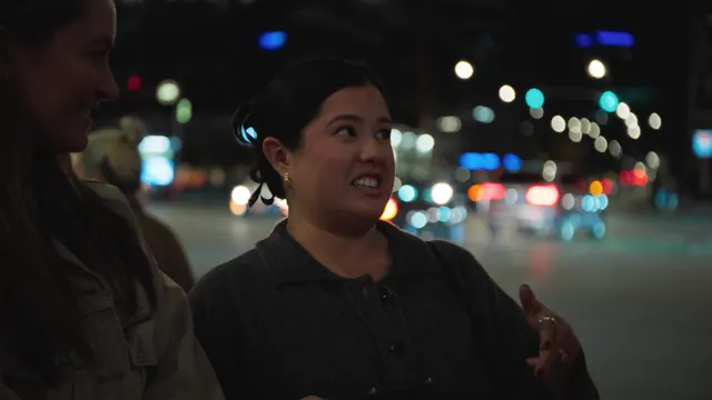 A woman talks to the filmmakers on a street in Chicago at night.
