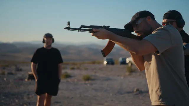 Tommy fires a rifle at the desert range outside Las Vegas, with Josh standing back.